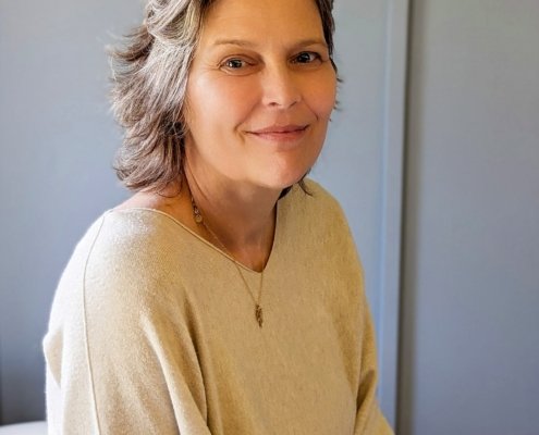 Portrait Birgit Gentis vor blauer Wand